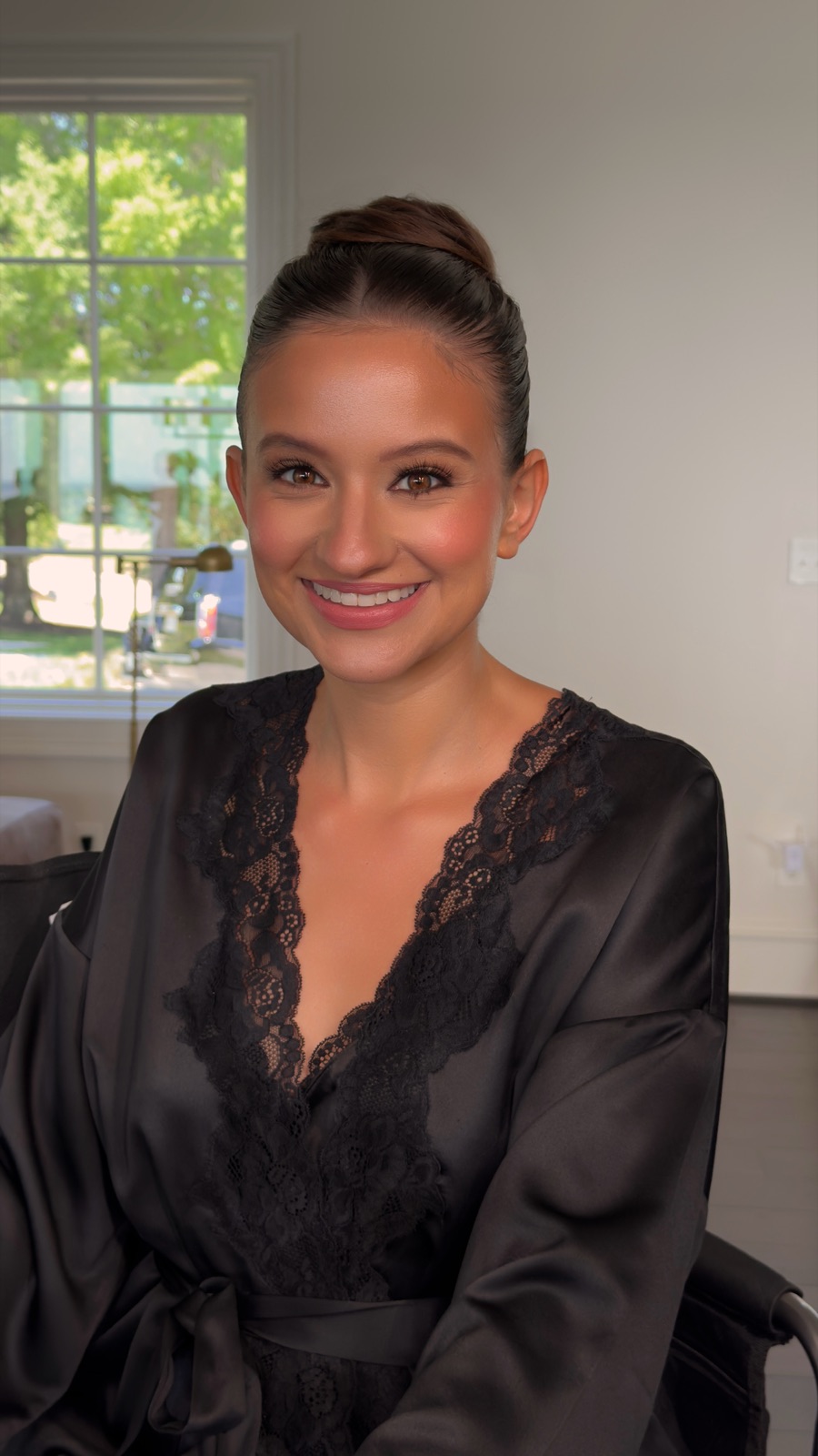 Bride with a sleek low bun and fresh, radiant skin in daylight